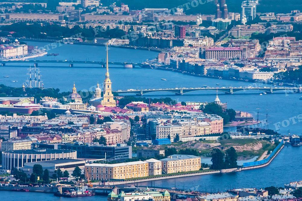 Этот снимок также демонстрирует панорамный вид на Санкт-Петербург с воздуха. В кадре видны изгибы реки Невы, многочисленные исторические здания, в том числе знаковые для города архитектурные сооружения и мосты. На переднем плане располагается Петропавловская крепость, а также знаменитый крейсер «Аврора». Это изображение может быть использовано в научных исследованиях, культурных публикациях, туристических проспектах, а также для создания фотоальбомов и постеров.